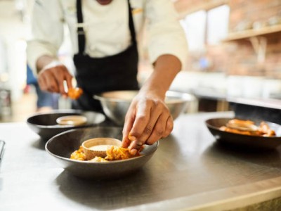 Close-up of male chef arranging food on a dish in the commercial kitchen